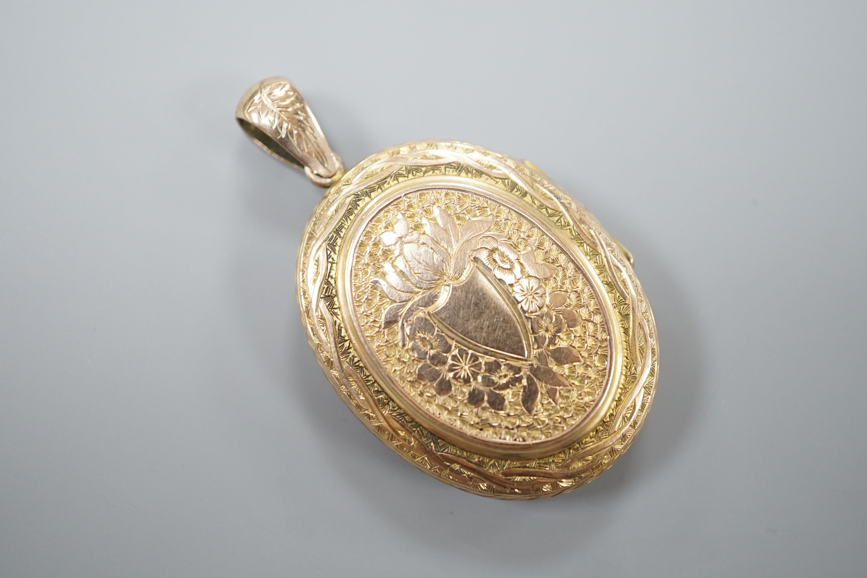A Victorian engraved yellow metal oval locket, overall 55mm, gross weight 15.5 grams.